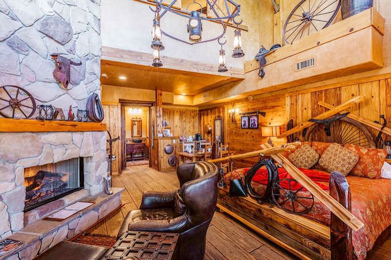 Silver Spur villa Western living room with a stone fireplace and leather chairs