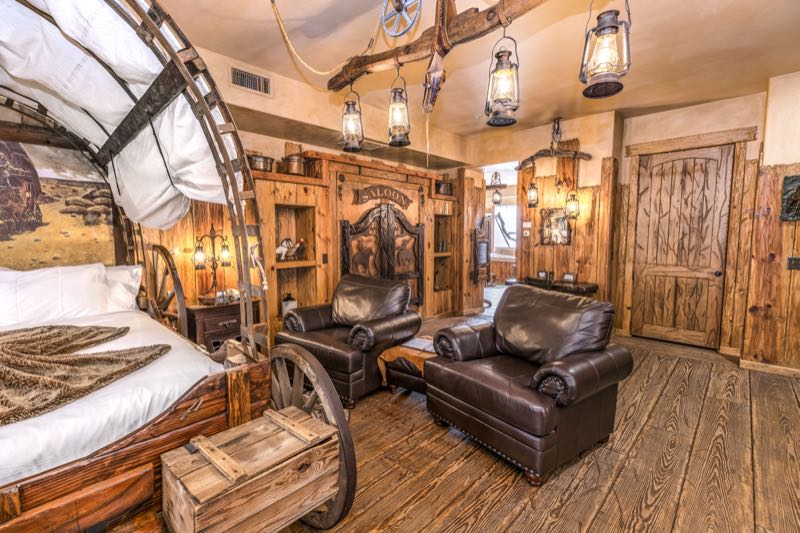 Wagon Wheel villa covered-wagon bed and leather armchairs